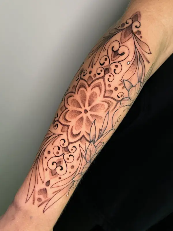 Mandala-style floral tattoo, forearm