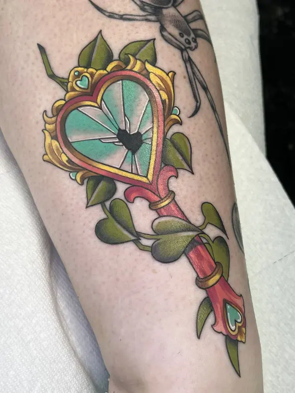 Full color shattered-heart key tattoo with leaves